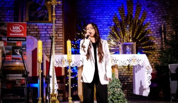dziewczyna śpiewa do mikrofonu w kościele - powiększ